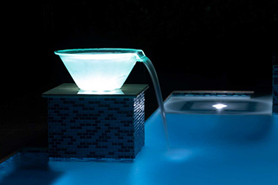 Blue light-up water bowl installed over inground swimming pool by Seaway Pools