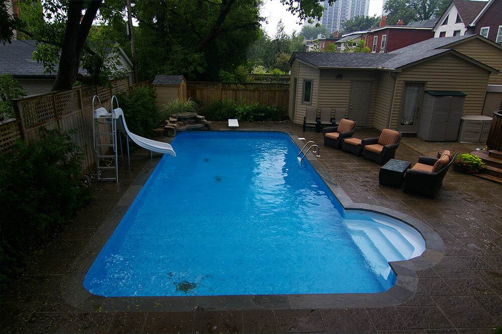 Pool installation with pool slide & outdoor furniture by Seaway Pools & Hot Tubs