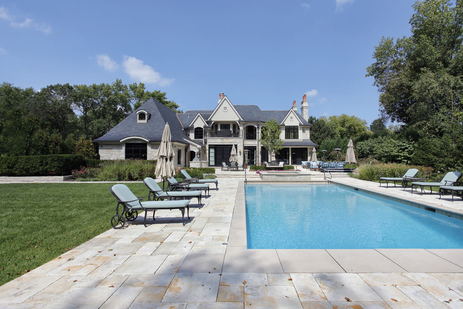 Beautiful landscape design & renovation in Vaughan backyard with inground rectangle pool, patio furniture & stonework.