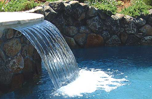 Backyard renovation with sheer descent waterfall installed over custom Seaway Pool